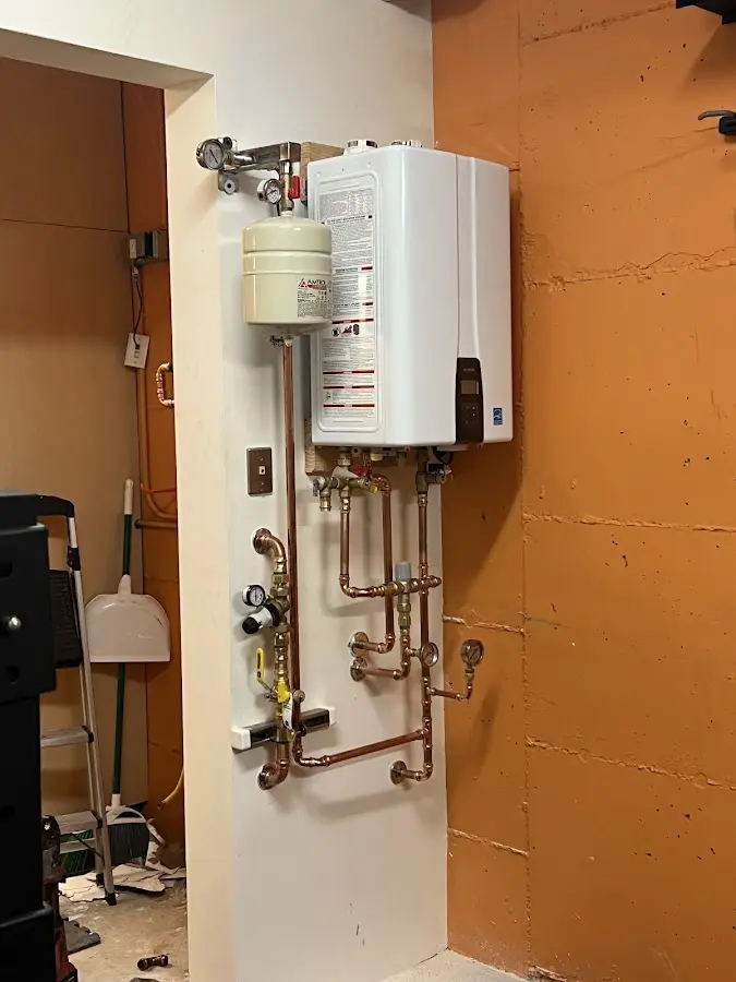 Plumbing technician inspecting water heater connections in Streator